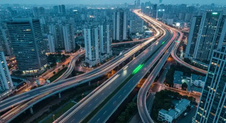 Aerial view of a vibrant city at dusk, showing geometric patterns of illuminated highways and modern skyscrapers, representing urban evolution.