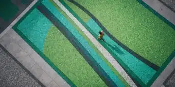 An aerial drone photograph of a person walking on a geometric mosaic pathway in a city plaza, symbolizing cultural and technological convergence.