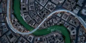 High-altitude aerial drone view of a city where a green river, an ancient stone mosaic, and a futuristic monorail converge, symbolizing the interplay of creative ideas, cultural insights, and future trends in modern living.